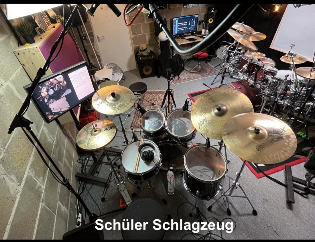 Schlagzeug mit Kopfhörer und Sticks auf der Snare für gehörschonenden Unterricht